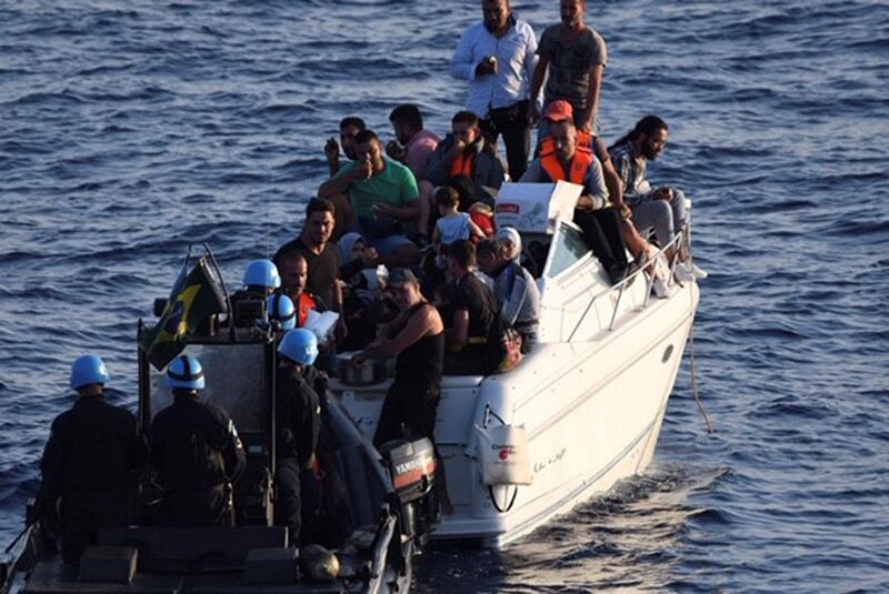 In this photo taken Thursday, Oct. 11 and released Friday Thursday, Oct. 12, 2018 by United Nations Interim Force in Lebanon (UNIFIL), Brazilian Navy motor boat from the United Nations Interim Force in Lebanon (UNIFIL) approaches a boat overcrowded with migrants in the Mediterranean Sea. The U.N. peacekeeping force in Lebanon says it has helped in rescuing 32 migrants on a boat who were trying to reach the Mediterranean island of Cyprus. The force known as UNIFIL said on Friday that migrants who were rescued the day before were 19 men, six women and seven children.(UNIFIL via AP)