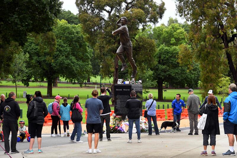 People pay their respects at a statue of former Australian cricket great Shane Warne outside the Melbourne Cricket Ground. AFP