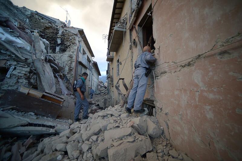 Rescuers search for victims in damaged buildings after a strong heartquake hit Amatrice. Filippo Monteforte / AFP