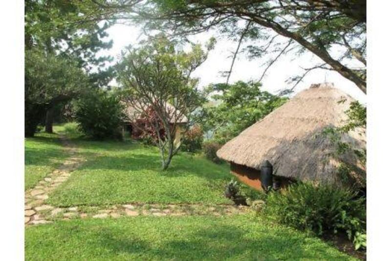 Ndali Lodge's six thatched cottages are dotted along a steep ridge beside a lake.