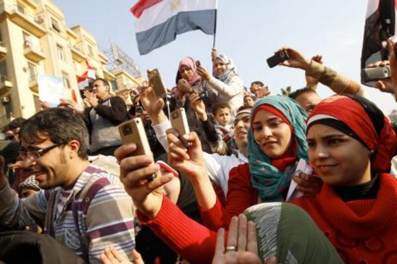 Egyptians use their mobile phone to record celebrations in Cairo's Tahrir Square, the epicentre of the popular revolt that drove veteran strongman Hosni Mubarak from power, on February 12, 2011. Thousands of Egyptians were still singing and waving flags as dawn broke over a nation reborn, after a popular uprising toppled Mubarak. AFP PHOTO/MOHAMMED ABED