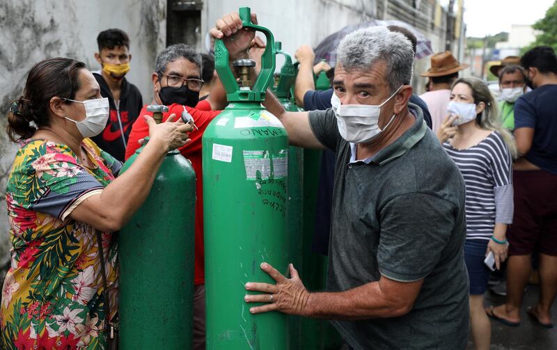 Relatives of patients hospitalised or receiving healthcare at home, mostly suffering of COVID-19, carry cylinders as they buy oxygen from a private company in Manaus, Brazil January 15, 2021. REUTERS/Bruno Kelly