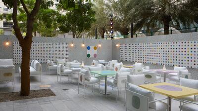 Damien Hirst's dot paintings line the walls of the outdoor terrace. Photo: Prada Mode