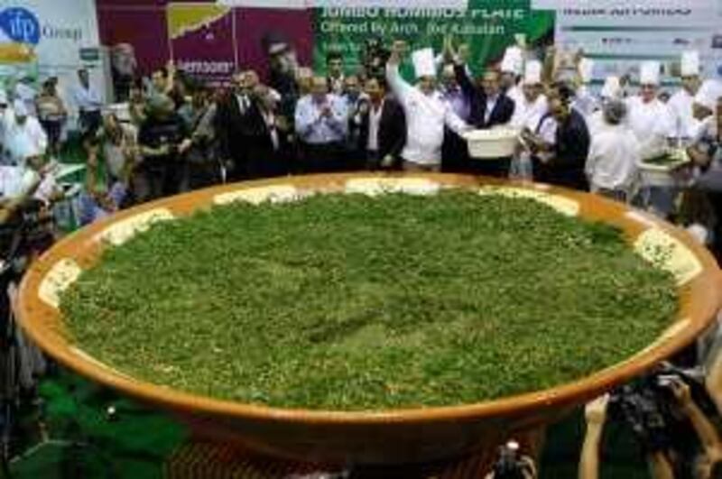 Lebanese chefs prepare a giant tabbouleh to set a new world record in Beirut on October 25, 2009. Under the watch of a Guinness adjudicator, 250 sous-chefs and their 50 bosses from the state-run culinary school chopped and sliced over three and a half tonnes (7,000 pounds) of the salad, using 1,600 kilogrammes (3,520 pounds) of parsley, 1,500 kilogrammes (3,300 pounds) of ripe tomatoes and 420 kilogrammes (926 pounds) of onions. The tabbouleh record came only a day after Lebanon broke a Guinness record with a two-tonne serving of the chickpea-based dip hummus. AFP PHOTO/RAMZI HAIDAR *** Local Caption ***  104163-01-08.jpg