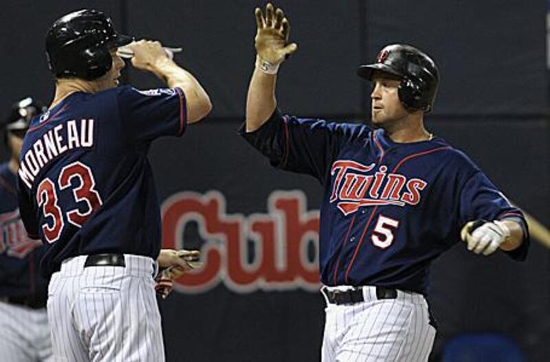 Michael Cuddyer, right, celebrates his two-run home run with teammate Justin Morneau which gave Minnesota a 4-3 win over divisional rivals the Chicago White Sox.