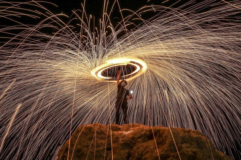 A Palestinian lights fireworks to celebrate Eid Al Adha in Khan Younis town, southern Gaza Strip. EPA