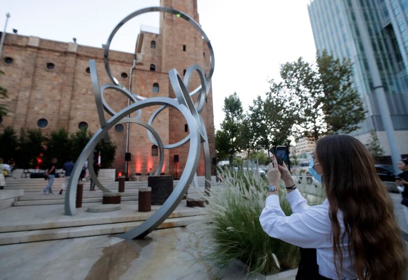 A woman photographs a sculpture by Lebanese artist Nayla Romanos Iliya, entitled 'On the Other Side of Time', a permanent artwork erected in front of the church of St Elias in Beirut. All photos: AFP