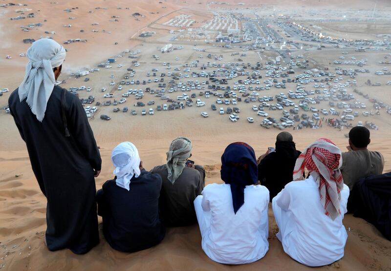 Abu Dhabi, United Arab Emirates, January 2, 2020.  4X4 goers watch different desert 4X4 mobiles go up the Al Al Moreeb Dune at the 2020 Liwa Festival.
Victor Besa / The National
Section:  NA
Reporter:  Haneen Dajani
