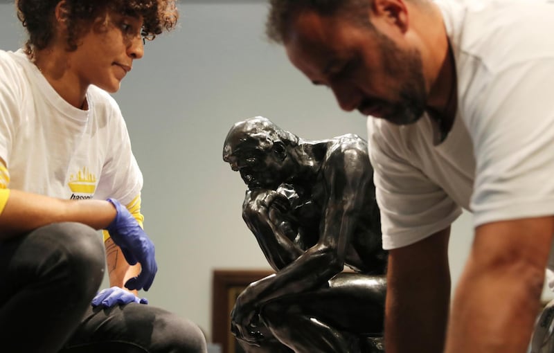 Staff members prepare to move Rodin's 'The Thinker' bronze statue during installation at the Louvre Museum in Abu Dhabi. Kamran Jebreili / AP photo