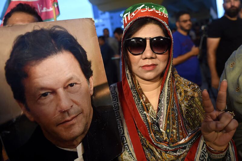 A supporter of Pakistan's former prime minister Imran Khan, gestures while holding Khan's portrait during a protest against the assassination attempt on him, in Karachi on November 6, 2022.  - Khan left hospital on November 6, a senior aide said, three days after being shot in the legs in a failed assassination attempt.  (Photo by Rizwan TABASSUM  /  AFP)