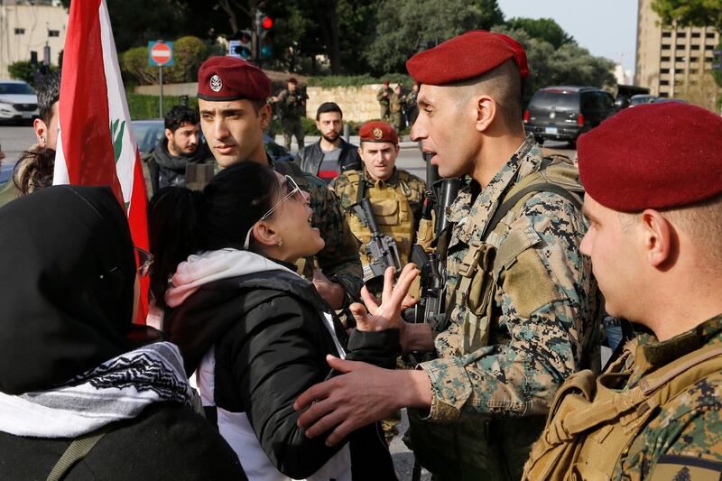 Army soldiers scuffle with anti-government protesters blocking a road leading to the parliament building in Beirut. AP