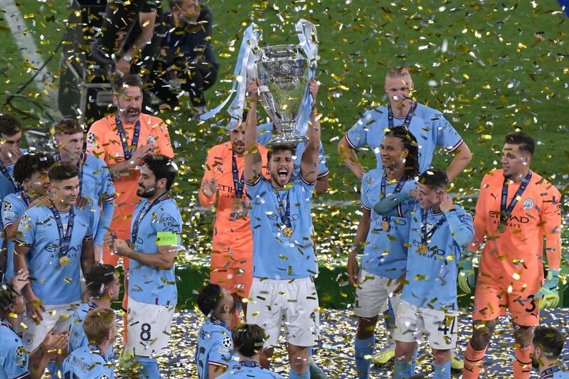 Manchester City's Portuguese defender #3 Ruben Dias (C) lifts the European Cup trophy as they celebrate on the podium after winning the UEFA Champions League final football match between Inter Milan and Manchester City at the Ataturk Olympic Stadium in Istanbul. AFP