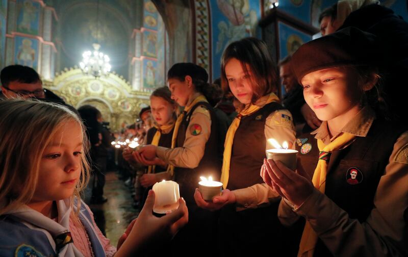 Members of the Plast National Scout Organisation of Ukraine share the Flame of Bethlehem during a ceremony to hand it over to the Metropolitan Epiphanius of Kyiv and All of Ukraine at St Mikhailovsky Cathedral in Kyiv last week. EPA