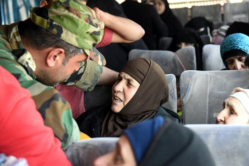 A soldier loyal to Syria's President Bashar al Assad forces talks to a woman in a bus after they were released by militants from Idlib, Syria May 1, 2018.   SANA/Handout via REUTERS THIS IMAGE HAS BEEN SUPPLIED BY A THIRD PARTY. REUTERS IS UNABLE TO INDEPENDENTLY VERIFY THIS IMAGE AS A SERVICE TO CLIENTS