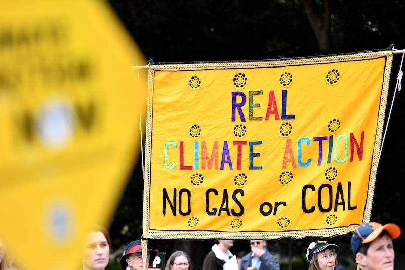 Protesters hold placards during a rally marking World Environment Day in Sydney. EPA