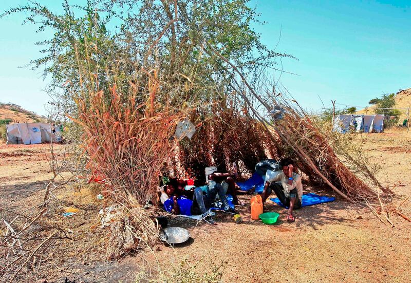 Ethiopian refugees who fled fighting in Tigray province lay in the shade in a straw shack at the Um Rakuba camp in Sudan's eastern Gedaref province. AFP