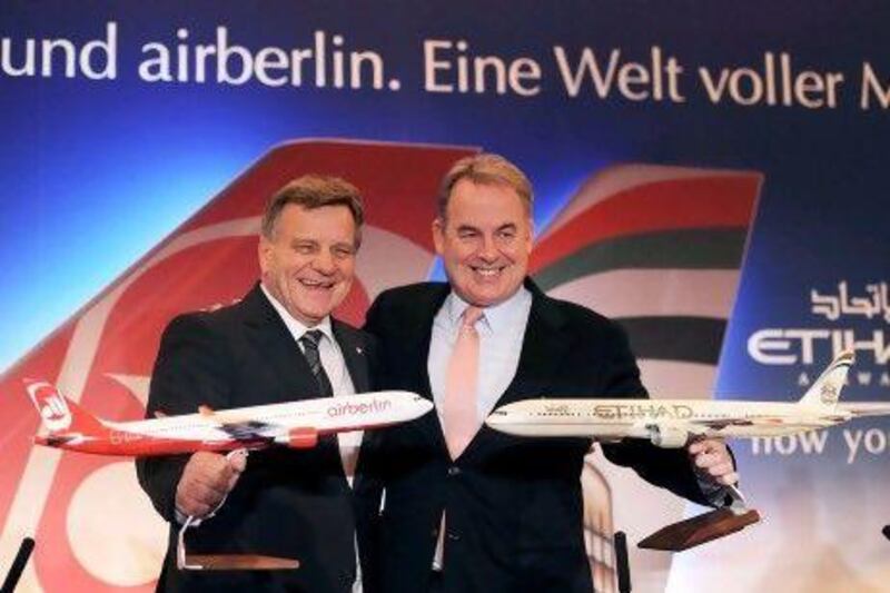 James Hogan, right, the chief executive of Etihad Airways and Hartmut Mehdorn, the chief executive of Air Berlin, yesterday announced at a press conference in Berlin that the Abu Dhabi carrier had raised its stake in Air Berlin to almost 30 per cent. Rainer Jensen / EPA