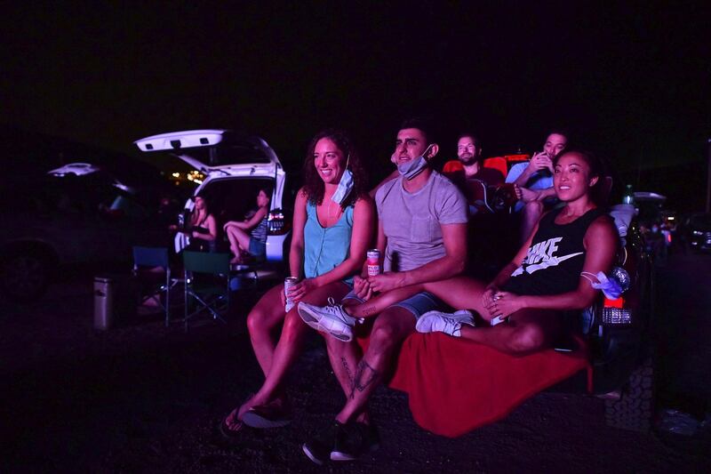 People share a laugh while watching The Big Lebowski during a drive-in movie theatre screening at the Red Rocks Amphiteatre in Morrison, Colorado.  AFP