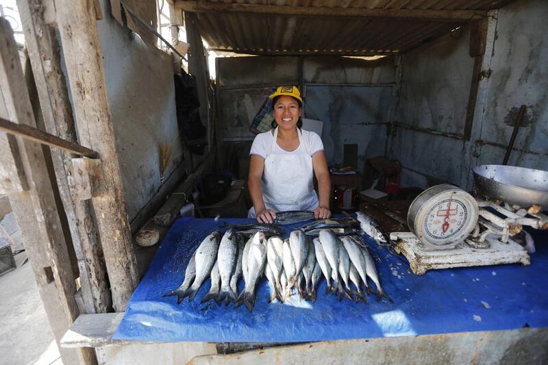 Margarita Perez poses in her fish stand in Gosen City. Perez is a single mother who supports her two children by selling fresh fish. Mariana Bazo / Reuters
