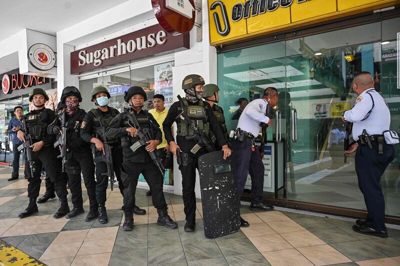 Members of a police SWAT team prepare to enter a mall after a hostage situation was reported in suburban Manila on March 2, 2020. Heavily armed police were deployed at the mall in the Philippine capital Manila after reports that a disgruntled employee was holding a group of people hostage, an AFP journalist saw. / AFP / Ted ALJIBE
