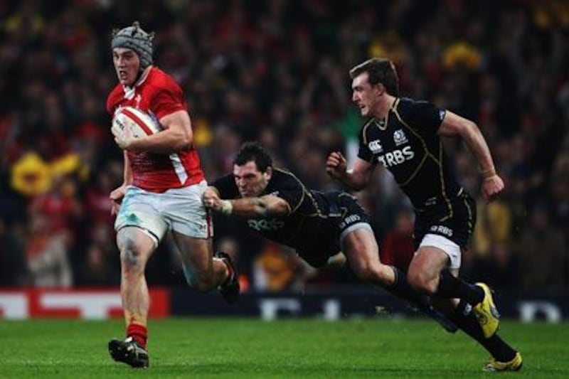 Wales' Dan Lydiate, left, holds off the tackle of Scotland's Sean Lamont.