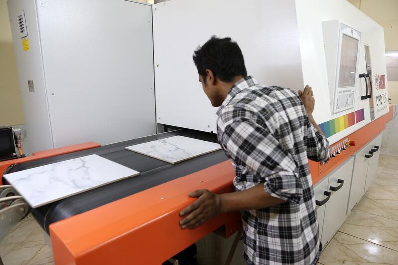A digital printer marks ceramic tiles at the RAK Ceramics factory. Pawan Singh / The National
