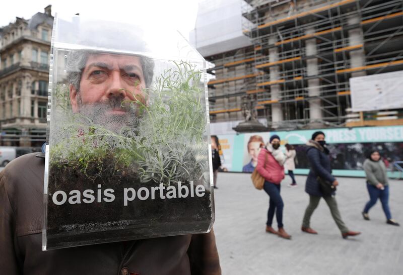Belgian artist Alain Verschueren wears his "Portable Oasis" while performing in a street, saying he wanted to be in his bubble in the middle of the city, in Brussels, Belgium. Reuters