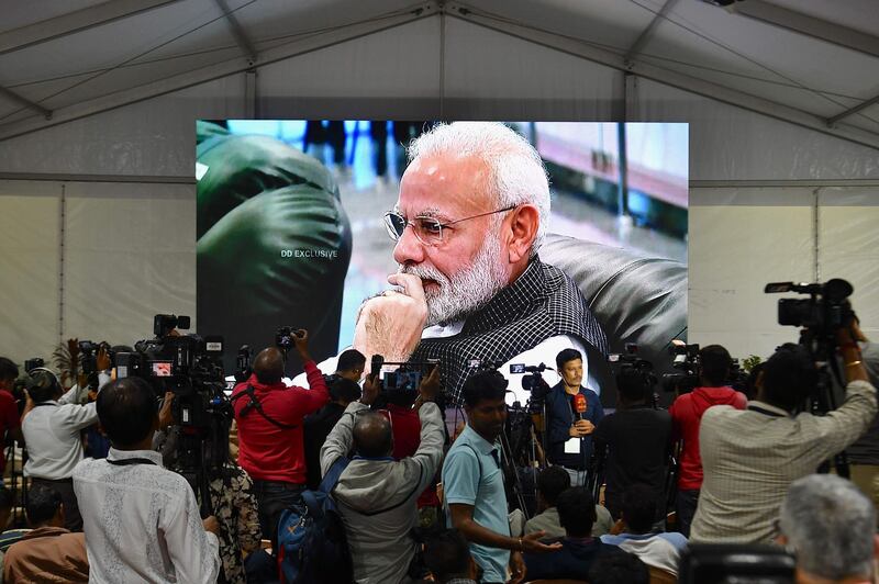 Members of the media cover the development as India's Prime Minister Narendra Modi is seen on a tv screen as he watches the live broadcast of the soft landing of spacecraft Vikram Lander of Chandrayaan-2 on the surface of the moon at ISRO Telemetry, Tracking and Command Network (ISTRAC) centre in Bangalore early on September 7, 2019. India lost communication with its unmanned spacecraft on September 7 just before it was due to land on the Moon, in a major setback to the country's lunar ambitions amid renewed interest in Earth's satellite. / AFP / Manjunath Kiran
