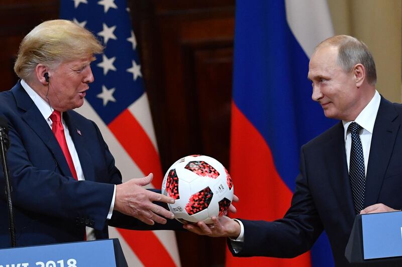 TOPSHOT - Russia's President Vladimir Putin (R) offers a ball of the 2018 football World Cup to US President Donald Trump during a joint press conference after a meeting at the Presidential Palace in Helsinki, on July 16, 2018. The US and Russian leaders opened an historic summit in Helsinki, with Donald Trump promising an "extraordinary relationship" and Vladimir Putin saying it was high time to thrash out disputes around the world.
 / AFP / Yuri KADOBNOV
