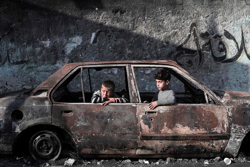 Children sit in a destroyed car in Rafah, in the south of the Gaza Strip. AFP