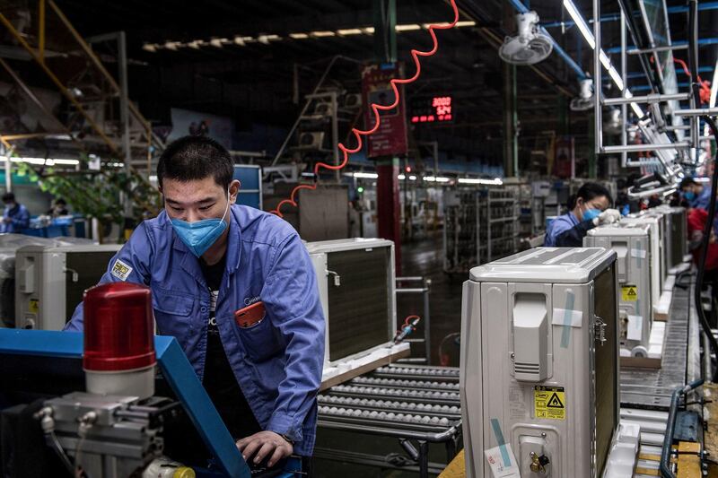 An employee works on an air conditioner production line at a Midea factory in Wuhan in China's central Hubei province on March 25, 2020. AFP