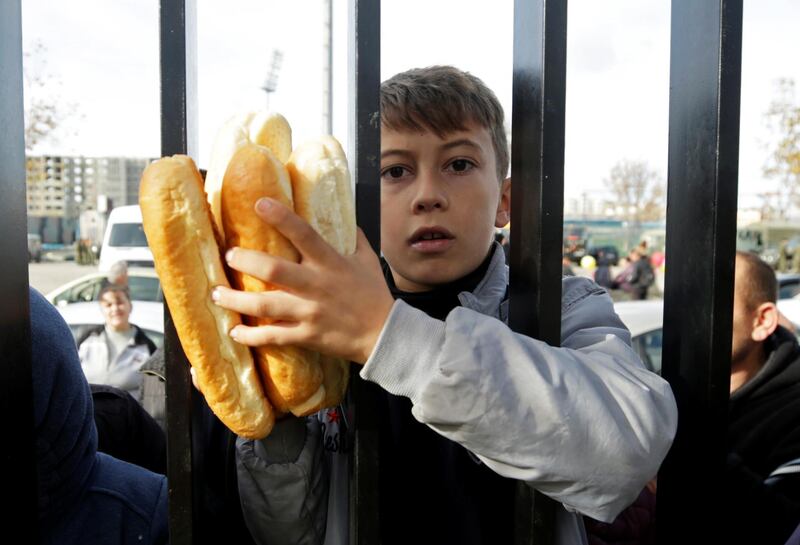 A child holds bread he received at a makeshift camp in Durres. Reuters