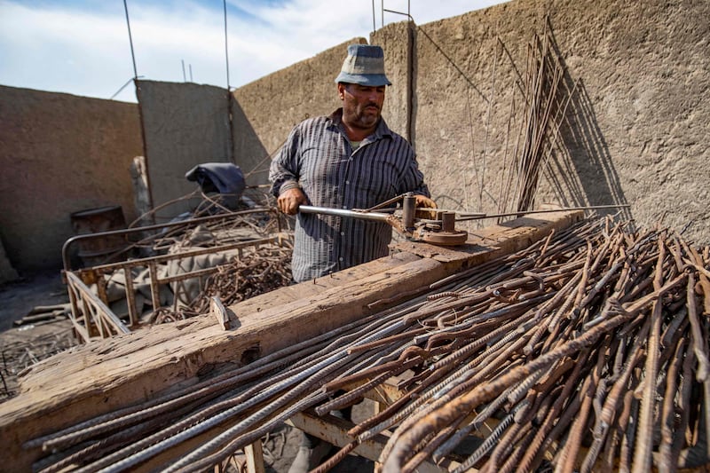 A man bends steel rods at a makeshift workshop in Raqqa.
