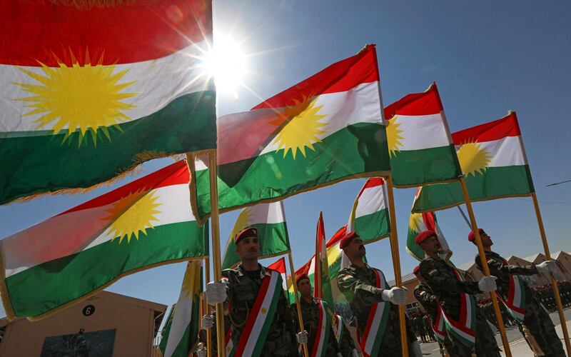 Members of the Iraqi-Kurdish Peshmerga carry Kurdish flags at the graduation ceremony. AFP