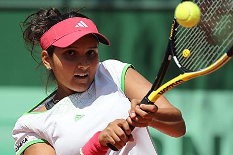 India's Sania Mirza hits a return in her 6-3, 6-3 first-round win against Germany's Kristina Barrois.