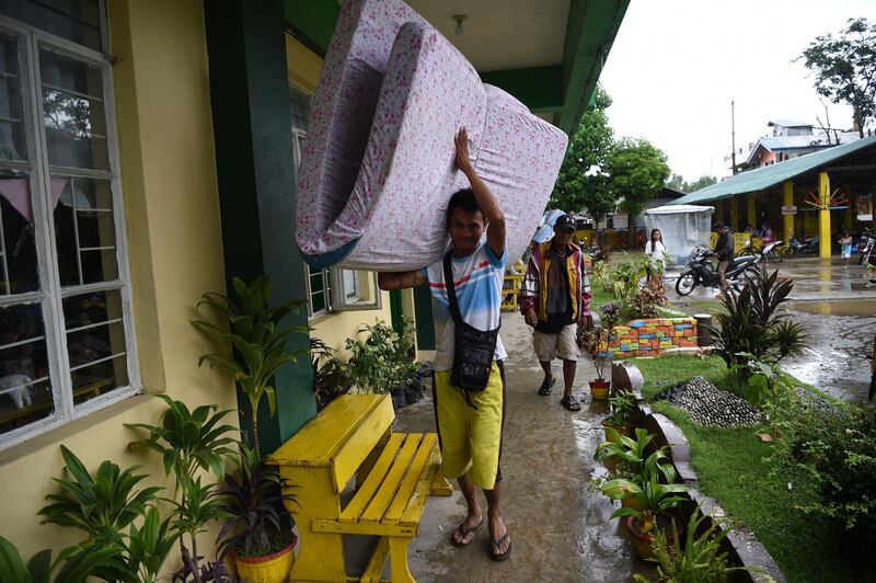A resident carries a matress inside a classroom being used as evacuation centre inTuguegarao, Cagayan province. Ted Aljibe / AFP