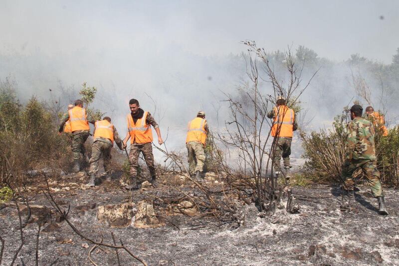 Firefighters tackle a forest fire in Safita. Reuters