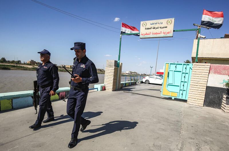 Iraqi policemen walk outside the river police headquarters by the Tigris in the centre of the capital Baghdad on May 10, 2019. Almost 200 people took their own lives in Iraq in the first four months of 2019, according to the government's Human Rights Commission. A senior police source told AFP that authorities had rescued 36 people, mostly men, attempting suicide between January and April. This follows a rise in suicides from 383 in 2016 to 519 last year recorded by the parliament's human rights committee. / AFP / AHMAD AL-RUBAYE
