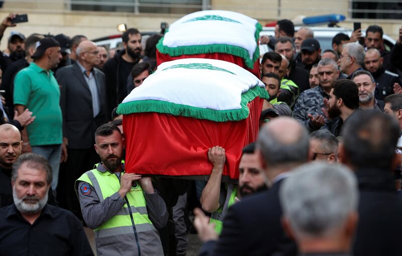 Civil defence members carry the coffins of the two journalists before the funeral, in Beirut. Reuters