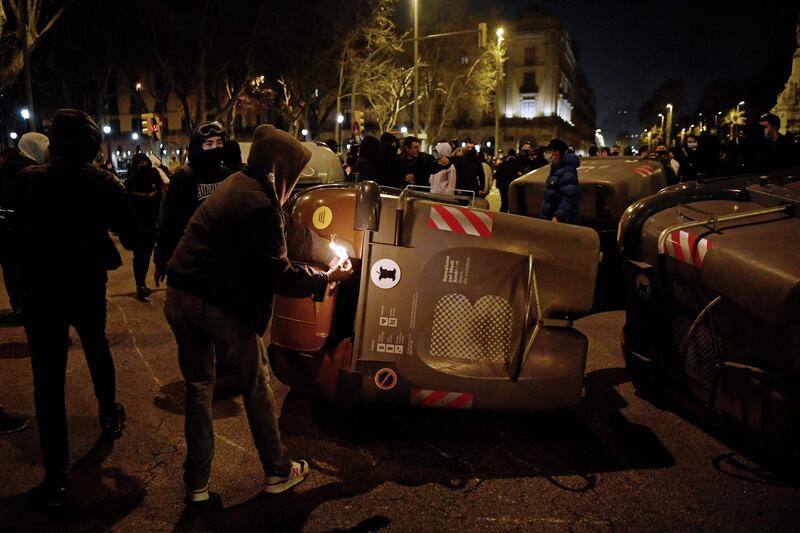 A protester sets fire to trash containers during clashes with Catalan regional police forces. AFP