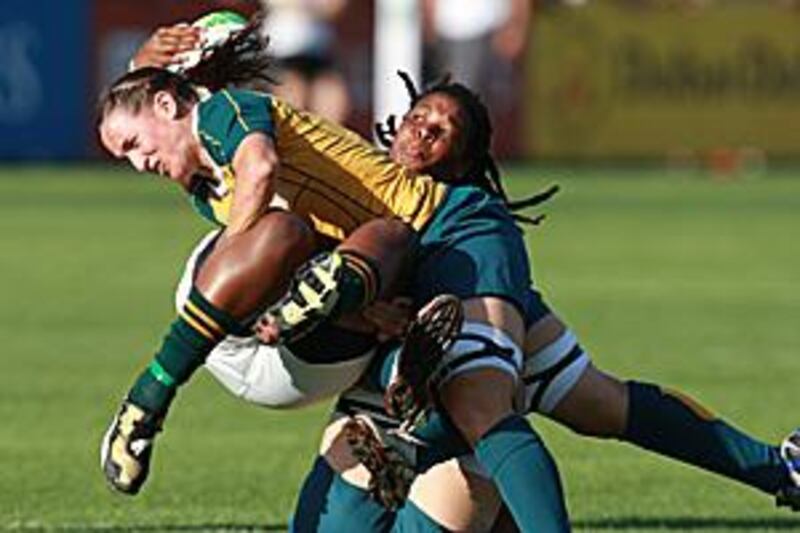 Mandisa Williams of South Africa, in green, and Sel Tranter of Australia, wrestle for the ball during their semi-final match in the World Cup Sevens.