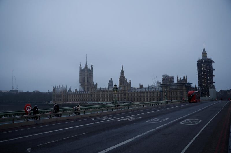 People wearing face masks push bikes across a deserted Westminster Bridge in London. AP Photo