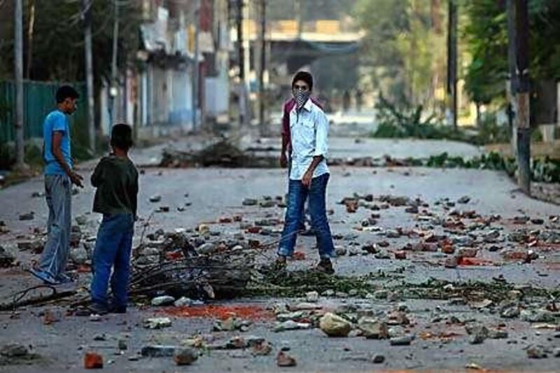 Kashmiri protesters pick their way across a road scattered with rubble in Srinagar after further demonstrations against New Delhi's rule.