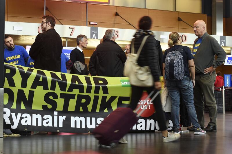 Travelers stand past a banner reading "Ryanair on strike" at Charleroi Airport in Gosselies, Belgium. AFP
