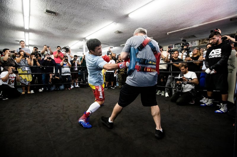 Manny Pacquiao hits the pads with trainer Freddie Roach. EPA