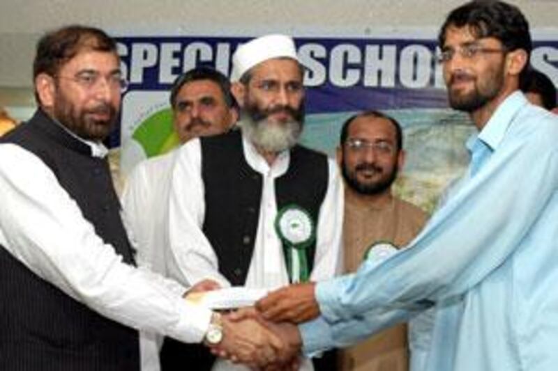 A university representative from Pakistan's disturbed areas, receives cash award from Riaz Farooq, left, the president of the Pak Association Dubai.