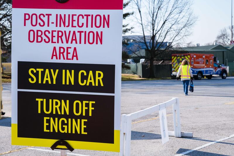 A volunteer walks past a sign with directions for drivers leaving the vaccination area outside of Broadbent Arena at the Kentucky State Fair and Exposition Center in Louisville, Kentucky. Jon Cherry / Getty Images / AFP