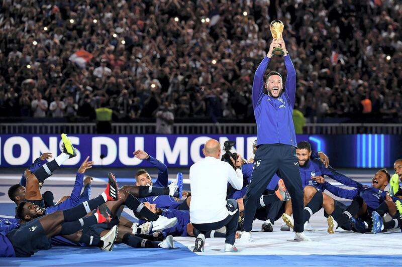 France's goalkeeper Hugo Lloris (C) holds the 2018 World Cup trophy as he celebrates with teammates during a ceremony to celebrate the victory of the 2018 World Cup before doing a lap of honour at the end of the UEFA Nations League football match between France and Netherlands at the Stade de France stadium, in Saint-Denis, northern of Paris, on September 9, 2018. / AFP PHOTO / Anne-Christine POUJOULAT