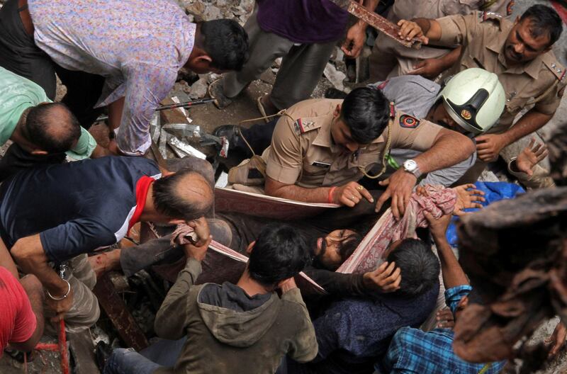 Rescue workers carry a man who was rescued from the rubble. Reuters