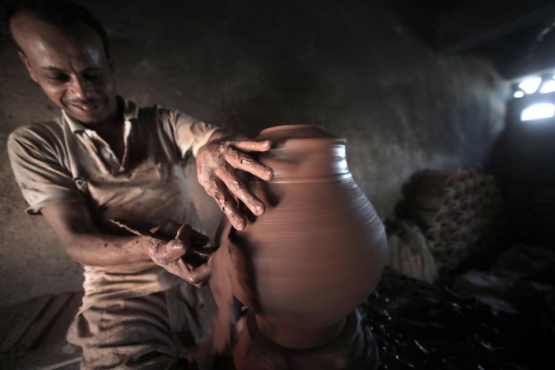 An Egyptian potter shapes a clay pot at one of the traditional pottery workshops, in Old Cairo, Egypt.